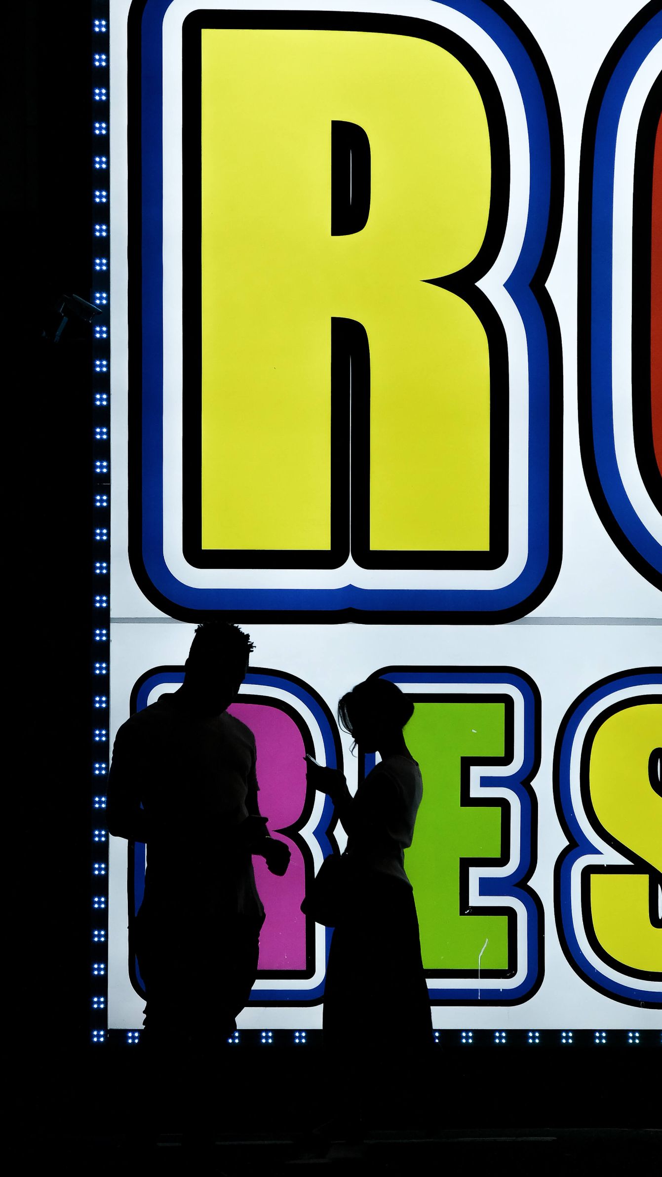 Although it looks like the two in the picture above are together, the woman was standing closer to the neon sign and the man, separate from the woman, standing towards the camera.
