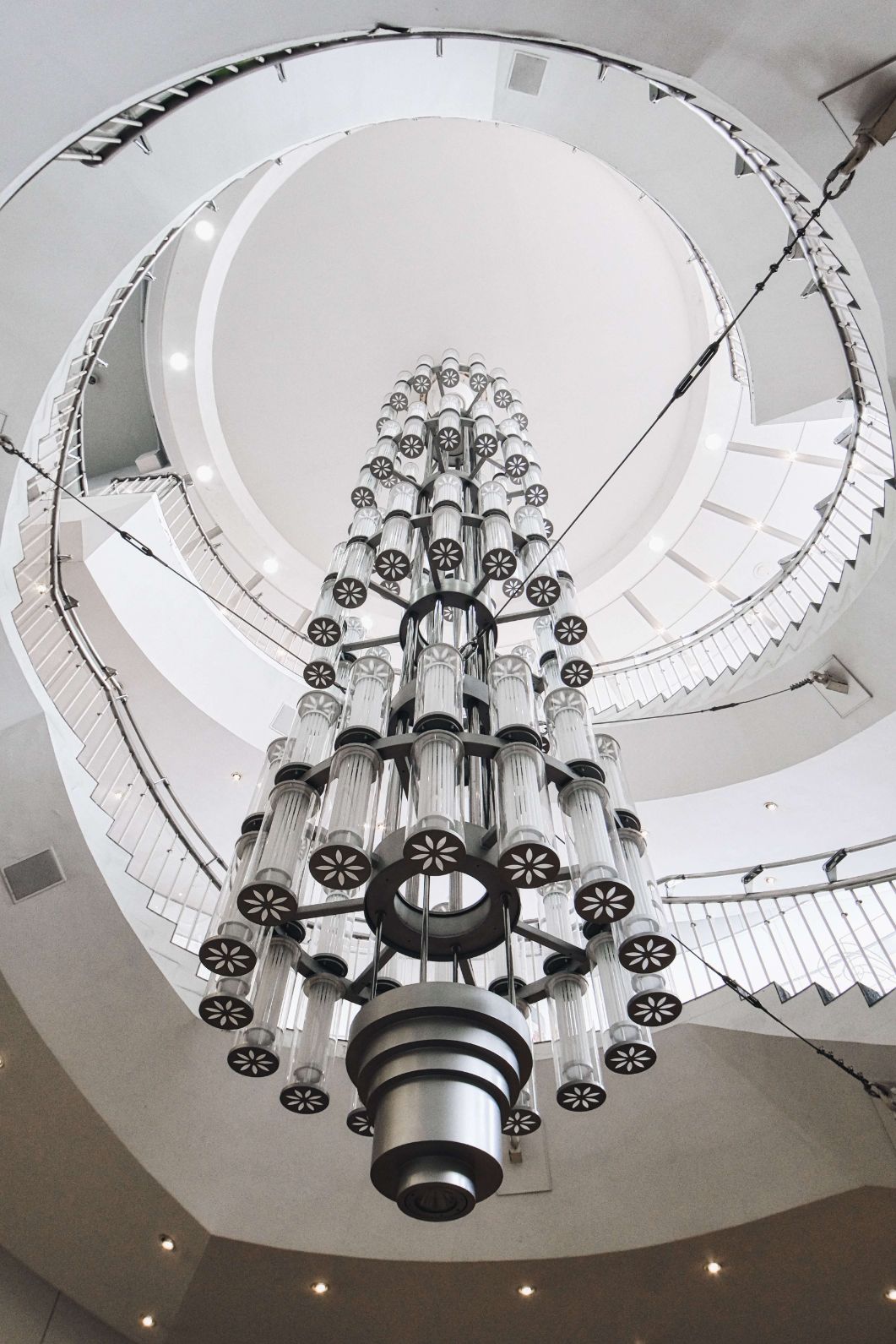 The chandelier drops down right in the middle of the spiral staircase. The long protruding chandelier acts as leading lines in the picture above.